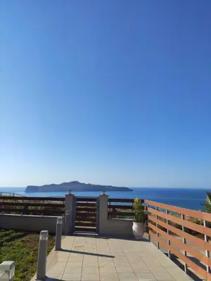 a patio with the ocean in the background at Wish Sea & Mountain View in Stalos