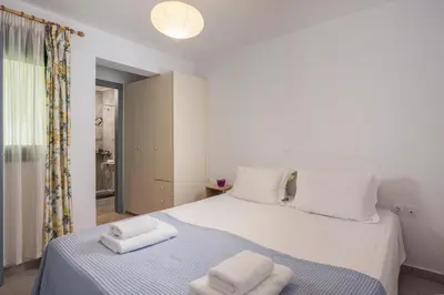 a bedroom with a white bed with towels on it at Peraspitaki in Chania Town