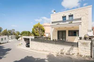 a white brick house with a porch on a street at Villa Antoni in Galatás
