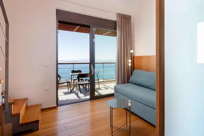 a living room with a blue couch and a balcony at Omnia Villas - 