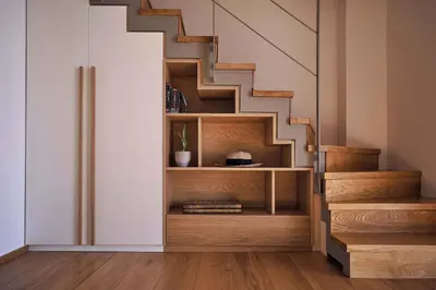 a staircase with a book shelf under a stair case at Omnia Villas - 