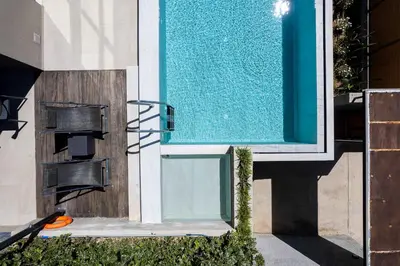 a glass door of a swimming pool next to a house at Omnia Villas - 