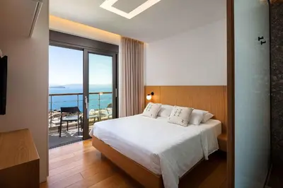 a bedroom with a bed with a view of the ocean at Omnia Villas - 
