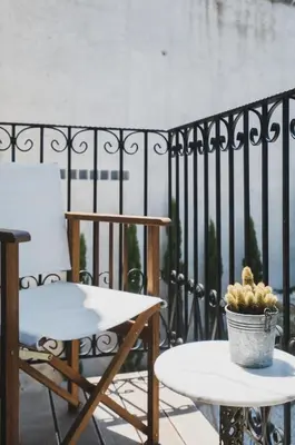 a chair and a table on a balcony with a plant at Casa Olea - A Venetian era Home with Courtyard in Kondomari