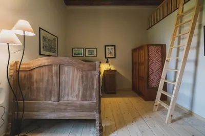 a bedroom with a wooden bed and a ladder at Casa Olea - A Venetian era Home with Courtyard in Kondomari
