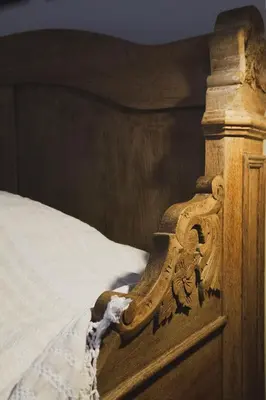 a wooden foot board of a bed with white sheets at Casa Olea - A Venetian era Home with Courtyard in Kondomari