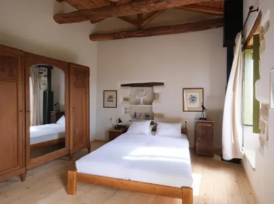 a bedroom with a white bed and a mirror at Casa Olea - A Venetian era Home with Courtyard in Kondomari