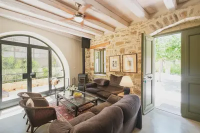 a living room with a couch and a table at Casa Olea - A Venetian era Home with Courtyard in Kondomari