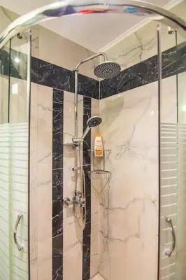 a shower in a bathroom with black and white marble at Apolafsi Apartments 2 New with kitchen in Chania Town