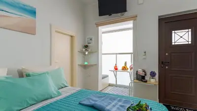 a bedroom with a bed with blue pillows and a door at Apolafsi Apartments 2 New with kitchen in Chania Town