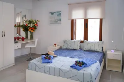 a bedroom with a blue bed with blue pillows at Apolafsi Apartments 1New with kitchen in Chania Town