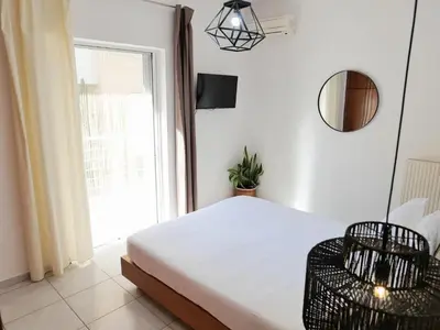 a bedroom with a bed and a chair and a window at Chania Locals Flat in Chania Town