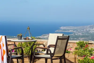 a table and chairs on a balcony with a view of the ocean at Traditional Crete Villa Villa Green Faskomilia Stunning Views 1 Bedroom in Khiliomoudhoú