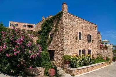 a stone building with flowers in front of it at Traditional Crete Villa Villa Orange Diktamos Stunning Views 1 Bedroom in Khiliomoudhoú