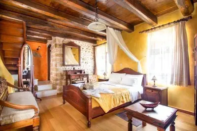 a bedroom with a bed and a table in a room at Traditional Crete Villa Villa Orange Diktamos Stunning Views 1 Bedroom in Khiliomoudhoú
