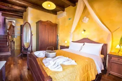 a bedroom with a bed with an orange bedspread at Samonas Traditional Villas Purple Villa Malotira - 85M² Maisonette in Khiliomoudhoú