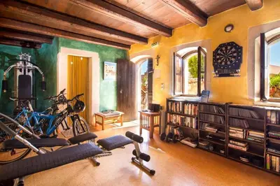 a gym with bikes and exercise equipment in a room at Samonas Traditional Villas Purple Villa Malotira - 85M² Maisonette in Khiliomoudhoú