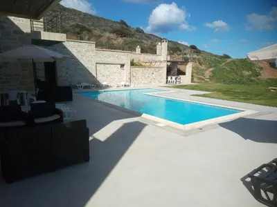 a swimming pool in front of a house at Villa Stylianos retreat in Kissamos