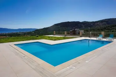 a large swimming pool with blue water in a yard at Villa Stylianos retreat in Kissamos