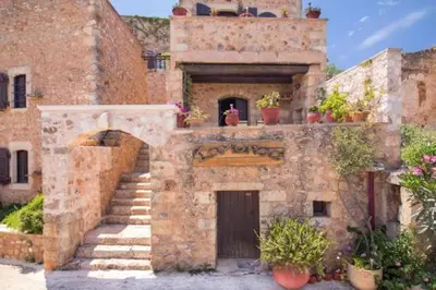 an old brick building with potted plants on it at Traditional Crete Villa Villa Blue Mantzourana Stunning Views 1 Bedroom in Khiliomoudhoú