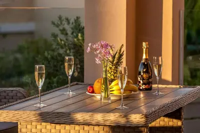 a table with wine glasses and a bottle of champagne at Luxury Villa Crete Villa Marina Mare 3 Bedroom Private Pool in Chania Town