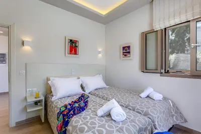 a bedroom with a bed with white pillows and a window at Luxury Villa Crete Villa Marina Mare 3 Bedroom Private Pool in Chania Town