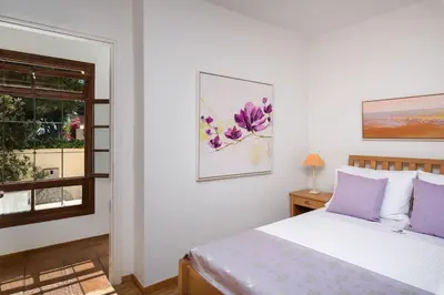 a bedroom with a bed with purple pillows and a window at Luxury Crete Villa Villa Koukounari Private Pool Beautiful Scenery in Chania Town