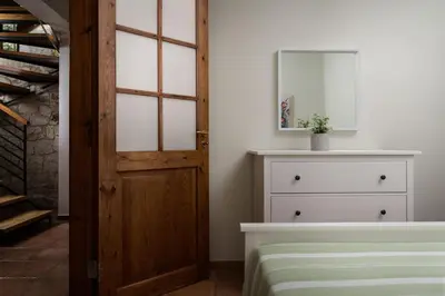 a bedroom with a door and a dresser with a mirror at Luxury Crete Villa Villa Koukounari Private Pool Beautiful Scenery in Chania Town