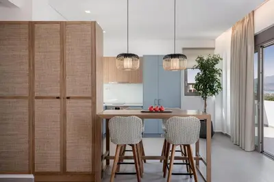 a kitchen with a wooden table and chairs at Anthos Villas - Chania in Tavronitis