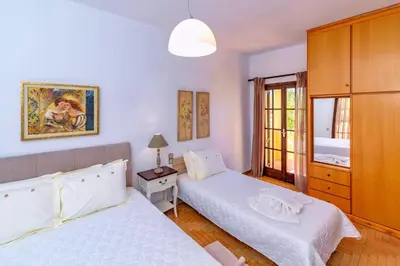 a bedroom with two beds and a lamp and a window at Exclusive Crete Villa Villa Alexia 4 Bedrooms Large Lawned Gardens in Maleme