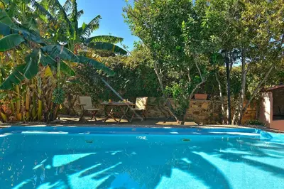 a blue swimming pool with a table and trees at Villa Kamares Private pool in Kondomari