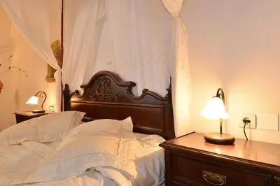 a bed with a wooden headboard and a table with a lamp at Villa Kamares Private pool in Kondomari