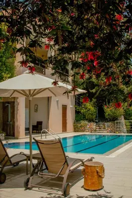 a pair of chairs and an umbrella next to a swimming pool at Villa Kalamitsi Luxury Villa in Apokorona Chania in Kariá