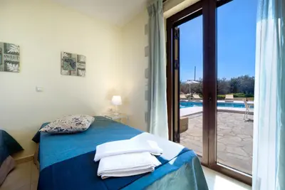 a bedroom with a bed with a view of a pool at Casa Rustica in Xirokámbion