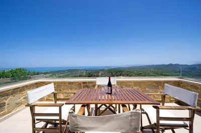 a table with a bottle of wine on a balcony at Casa Rustica in Xirokámbion