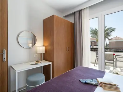 a hotel room with a bed and a mirror at Caldera Beach in Plataniás