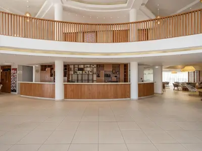 a large lobby with a large staircase in a building at Caldera Beach in Plataniás