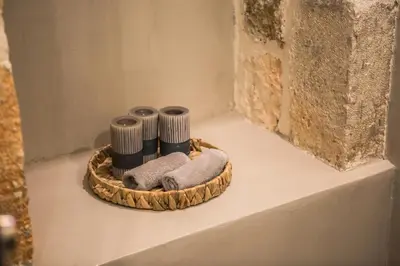 a basket with towels on a shelf next to a wall at The Peach House in Chania Town
