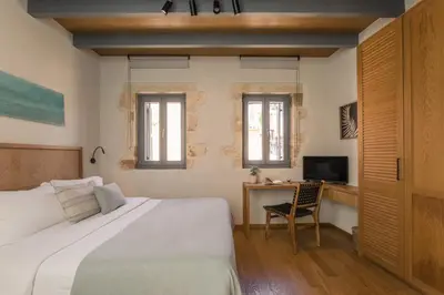 a bedroom with a bed and a desk with a television at The Peach House in Chania Town
