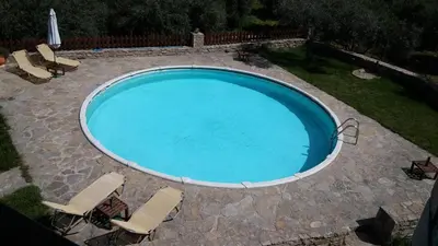 a large swimming pool with chairs in a yard at Stratos Villas in Melidhónion