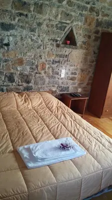 a bed in a room with a brick wall at Stratos Villas in Melidhónion