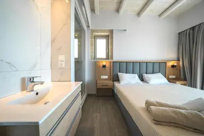 a bedroom with a bed and a bathroom with a sink at Nafsika Xenia Villa in Plátanos
