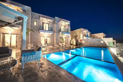 a villa with a swimming pool at night at Nafsika Xenia Villa in Plátanos