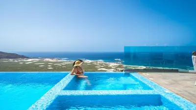 a woman in a swimming pool with the ocean in the background at Nafsika Xenia Villa in Plátanos
