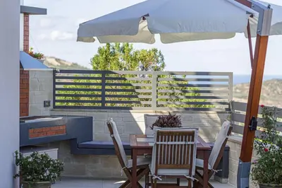 a table and chairs under an umbrella on a patio at Villa Chryssi in Kissamos