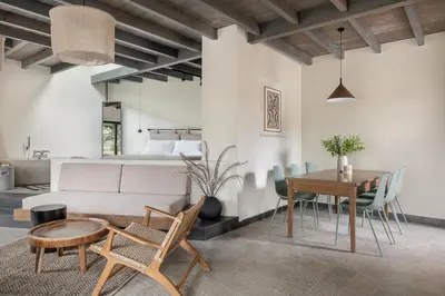 a living room with a table and chairs and a bed at Velanis Ηouse, style into nature - secluded in Kissamos