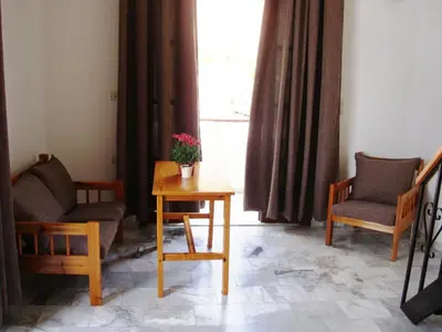 a living room with two chairs and a table and a window at Artemis Studios in Agia Roumeli