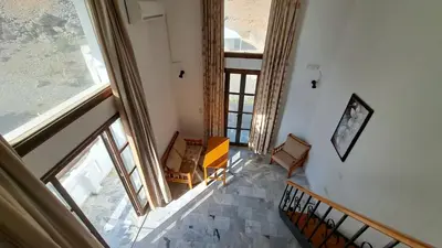 an overhead view of a hallway with chairs and windows at Artemis Studios in Agia Roumeli