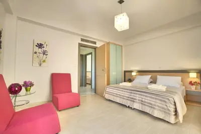 a bedroom with a bed and a red chair at Anemon Villas in Kissamos