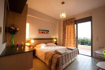 a bedroom with a bed and a large window at Anemon Villas in Kissamos